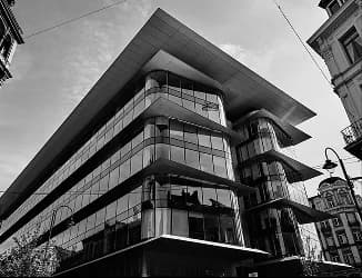 Immeuble contemporain à l’angle d’une rue, balcons filants vitrés