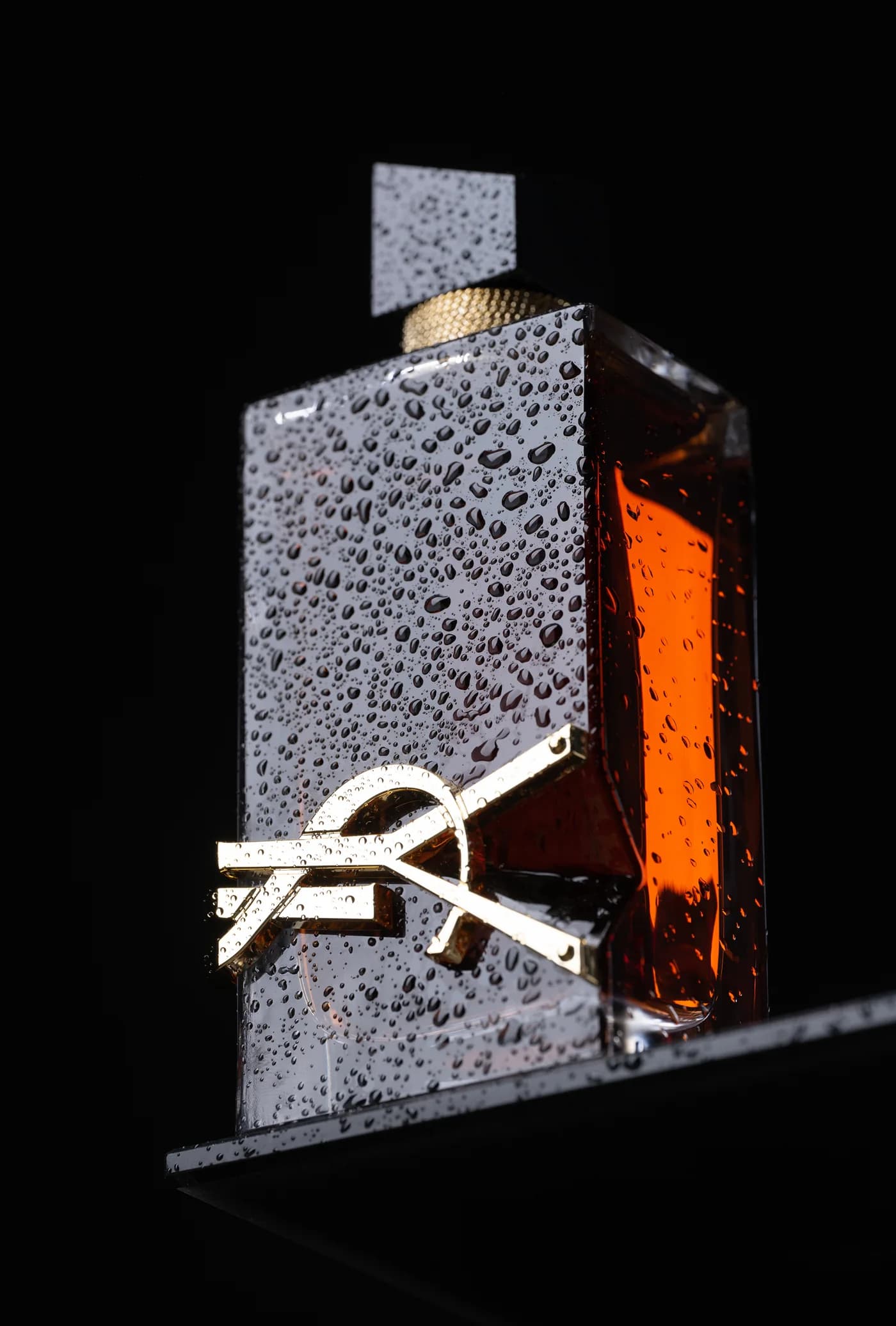 Flacon de parfum Yves Saint Laurent couvert de gouttes d’eau